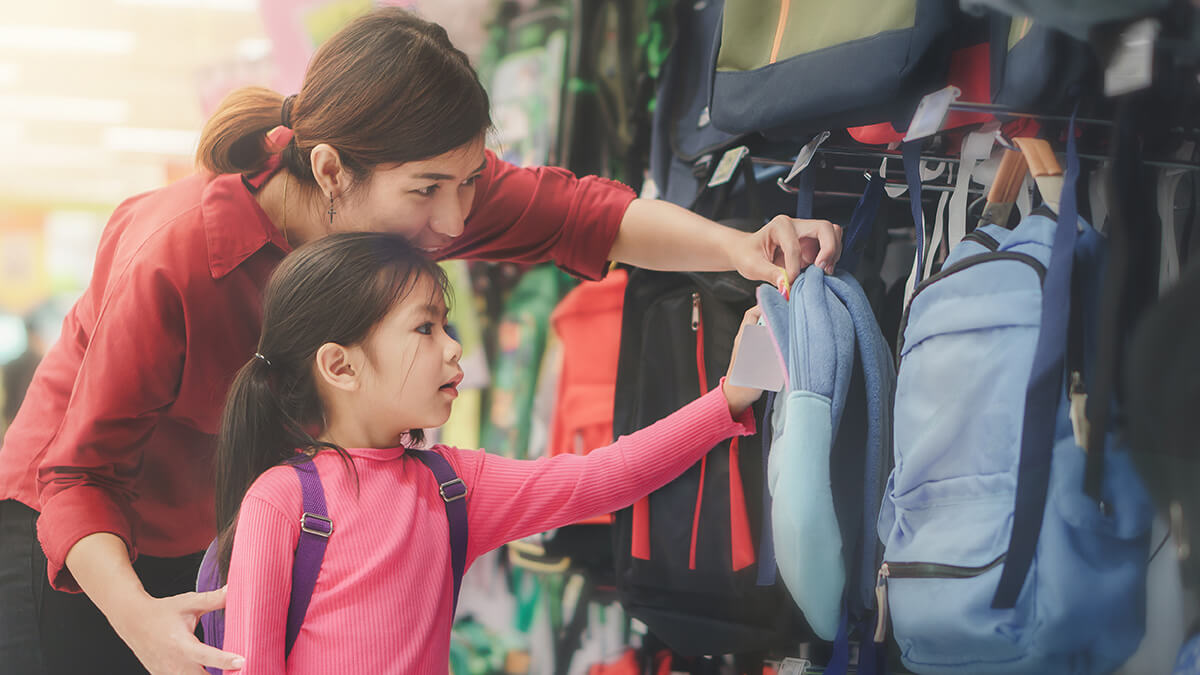 Mom and daughter picking out a new backpack