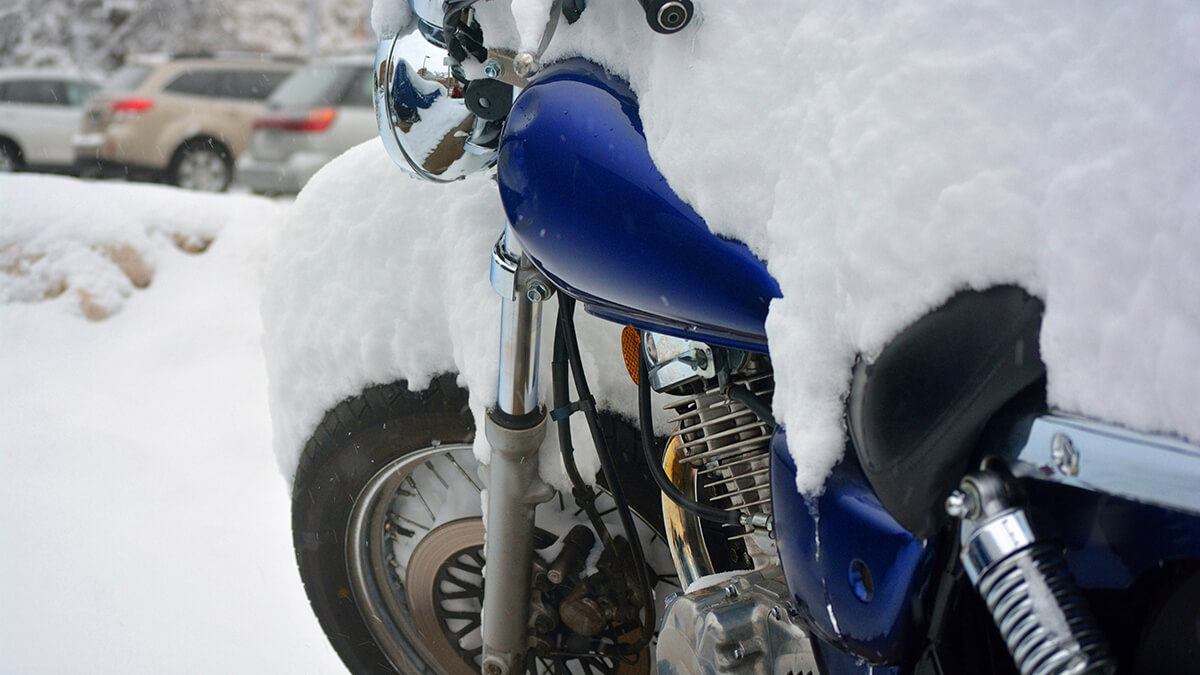 A snow covered bike sitting out in the frigid cold