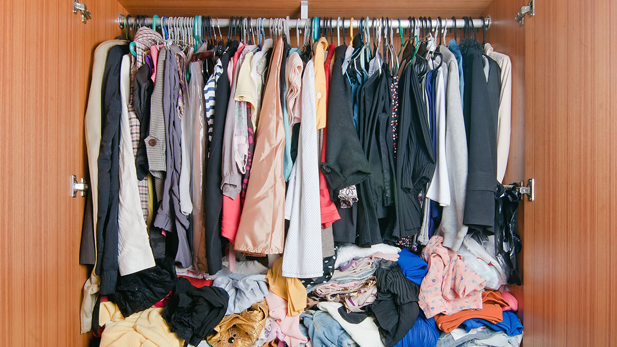 A walk-in closet cluttered with clothes