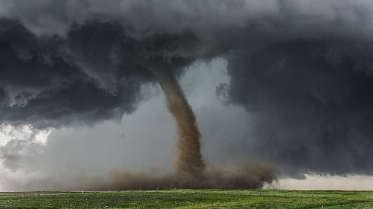 A menacing tornado whirling across an open plain