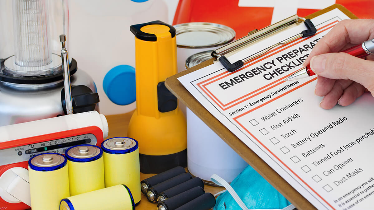 An emergency checklist with emergency supplies in background