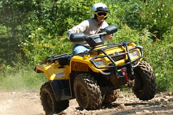 An ATV rider riding along a dirt path