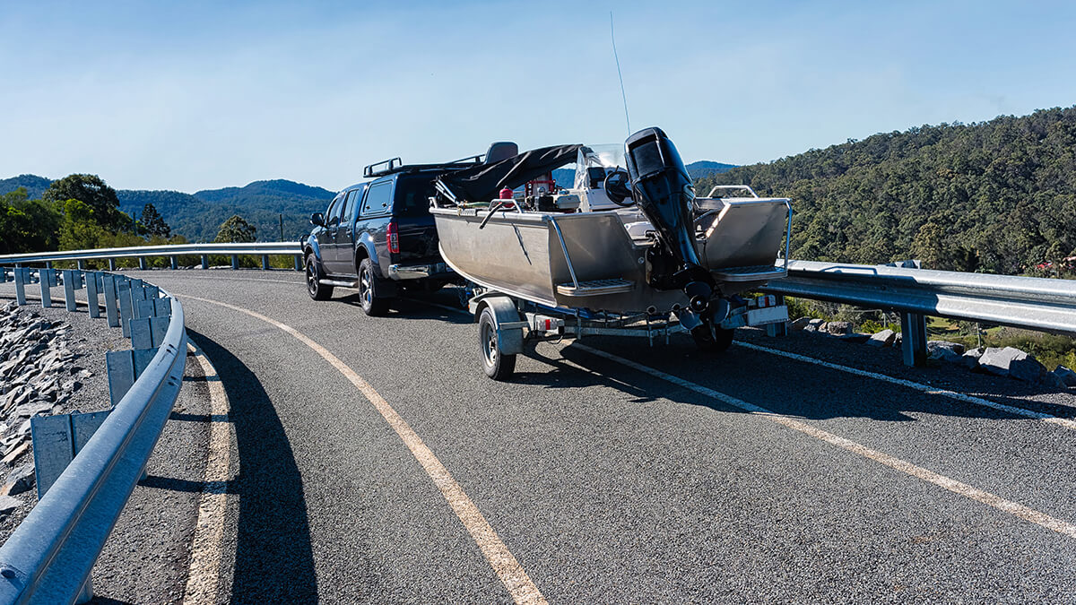 A pickup truck pulling a boat on highway