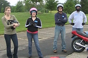 A group of people taking a motorcycle safety course outside