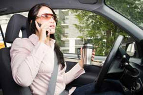 A woman driver being distracted with phone call