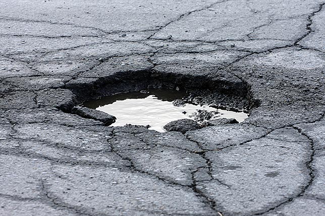 A pothole in the road filled with rain water