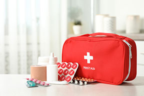 A red first aid kit bag with supplies to keep in your first aid bag