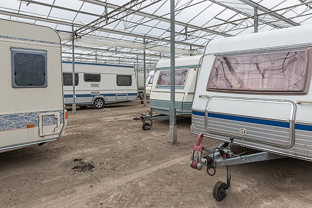 A handful of RVs in a winter storage facility
