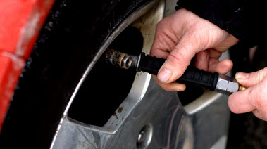 A person checking tire pressure